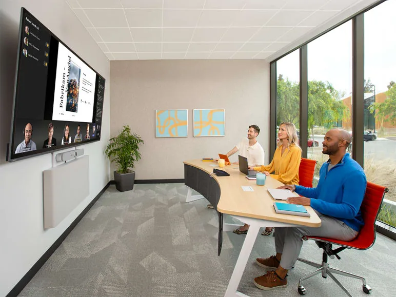 Team in a medium meeting room joining a video call on a wall display